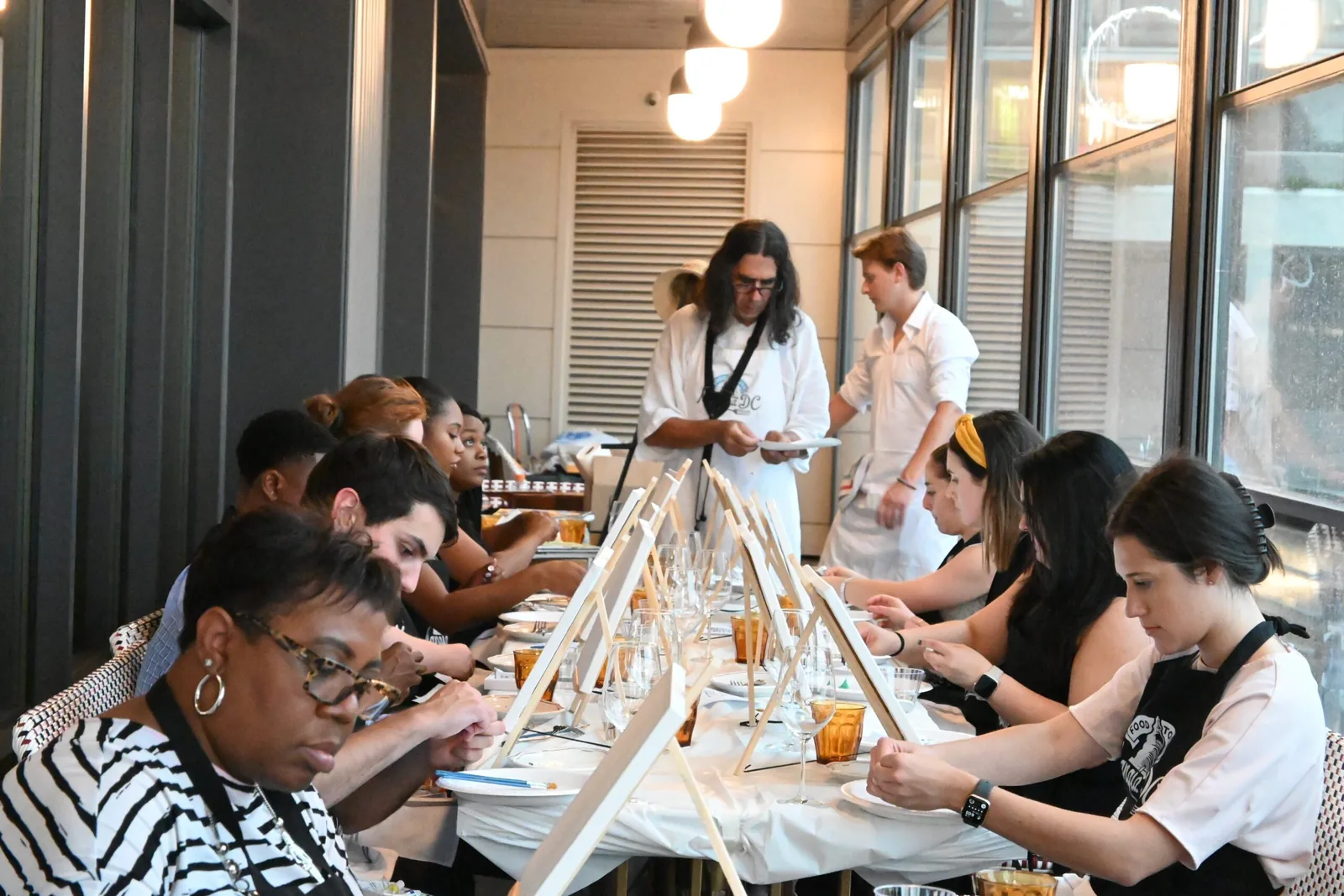 Guests seated at easels at a private paint and sip in a Washington, DC venue