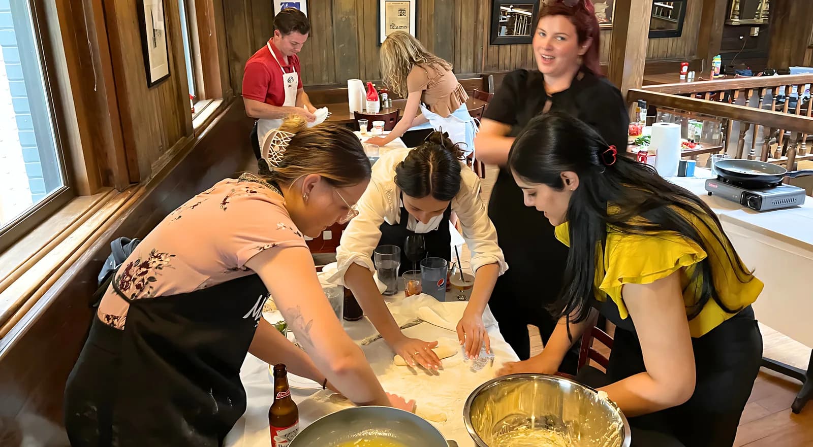 Team making fresh pasta by hand at a team building cooking class