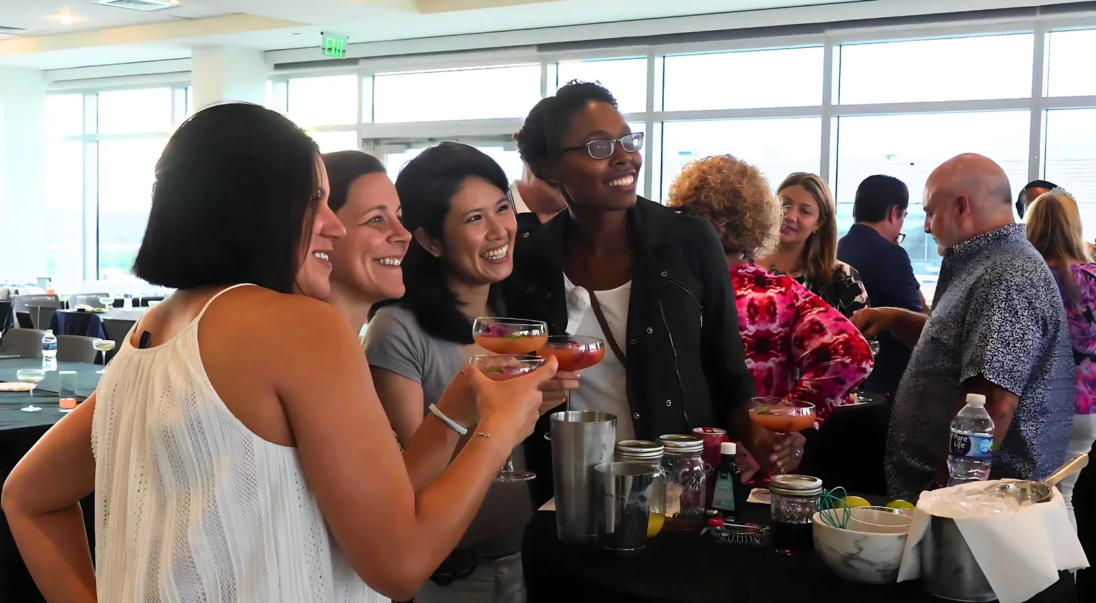 Team laughing with cocktails in hand at a private mixology class in Washington, DC
